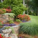 "Garden beds full of azaleas, petunias and lush miscanthus grass terrace down the hillside."